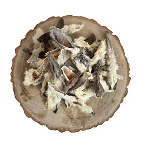 selection of loose, hairy rabbot ears natural dog treats displayed on a cross section log