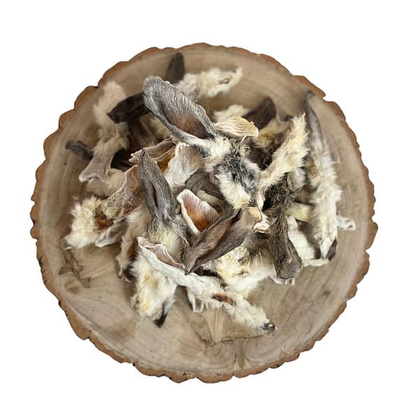 selection of loose, hairy rabbot ears natural dog treats displayed on a cross section log