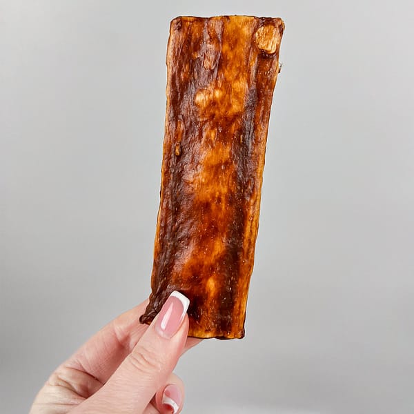 Chewllagen Beef Chips Hand 1000 6"x2" flat Collagen dog chew being held by a female hand